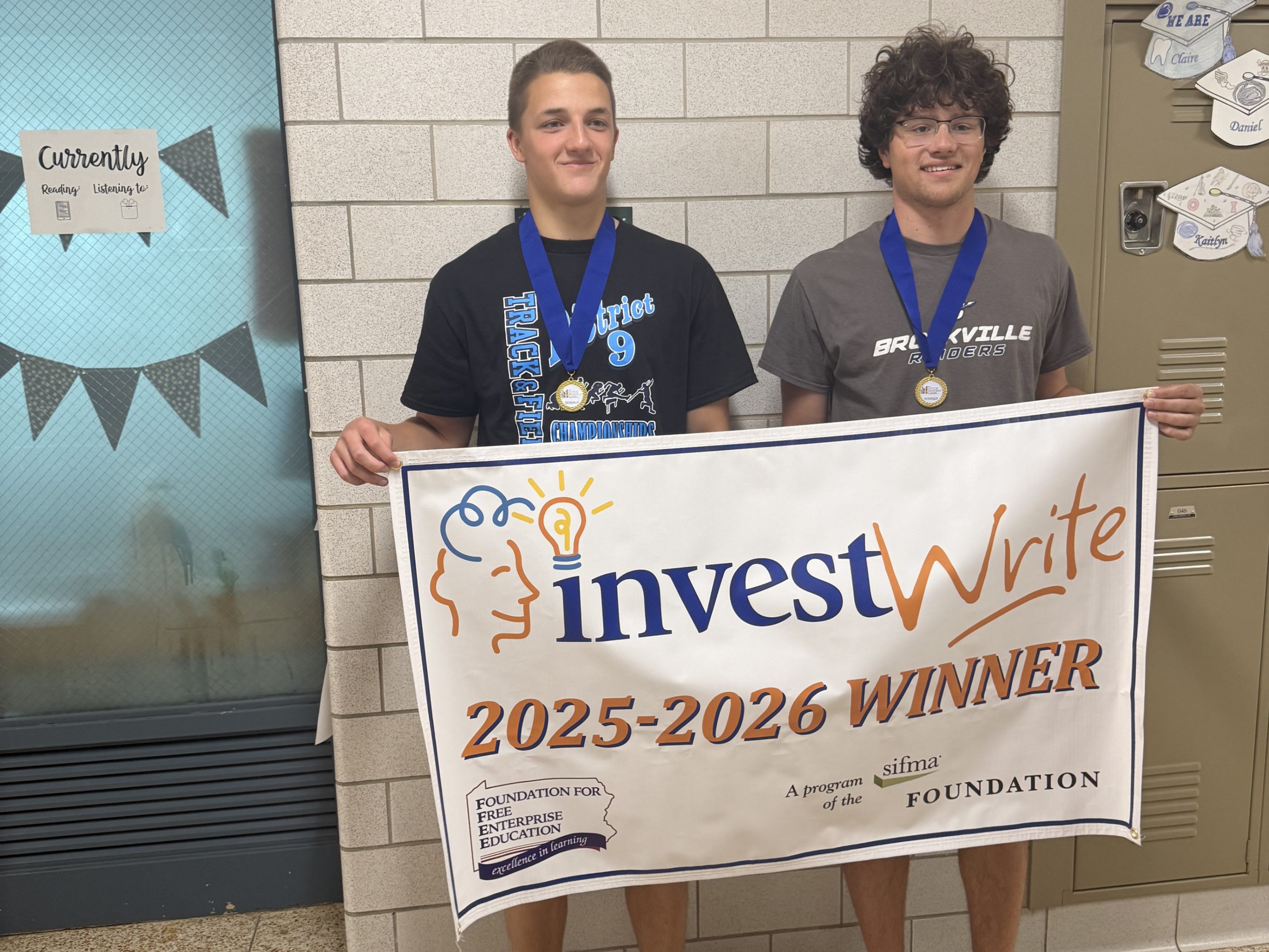 Aaron Turner and Rees Taylor hold an InvestWrite 2025-2026 Winner banner.